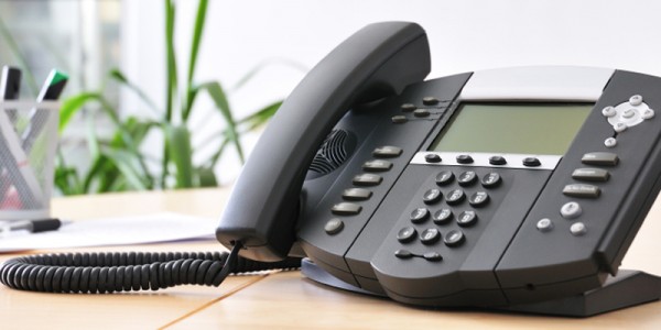 Advanced managerial VoIP phone on beech desk.